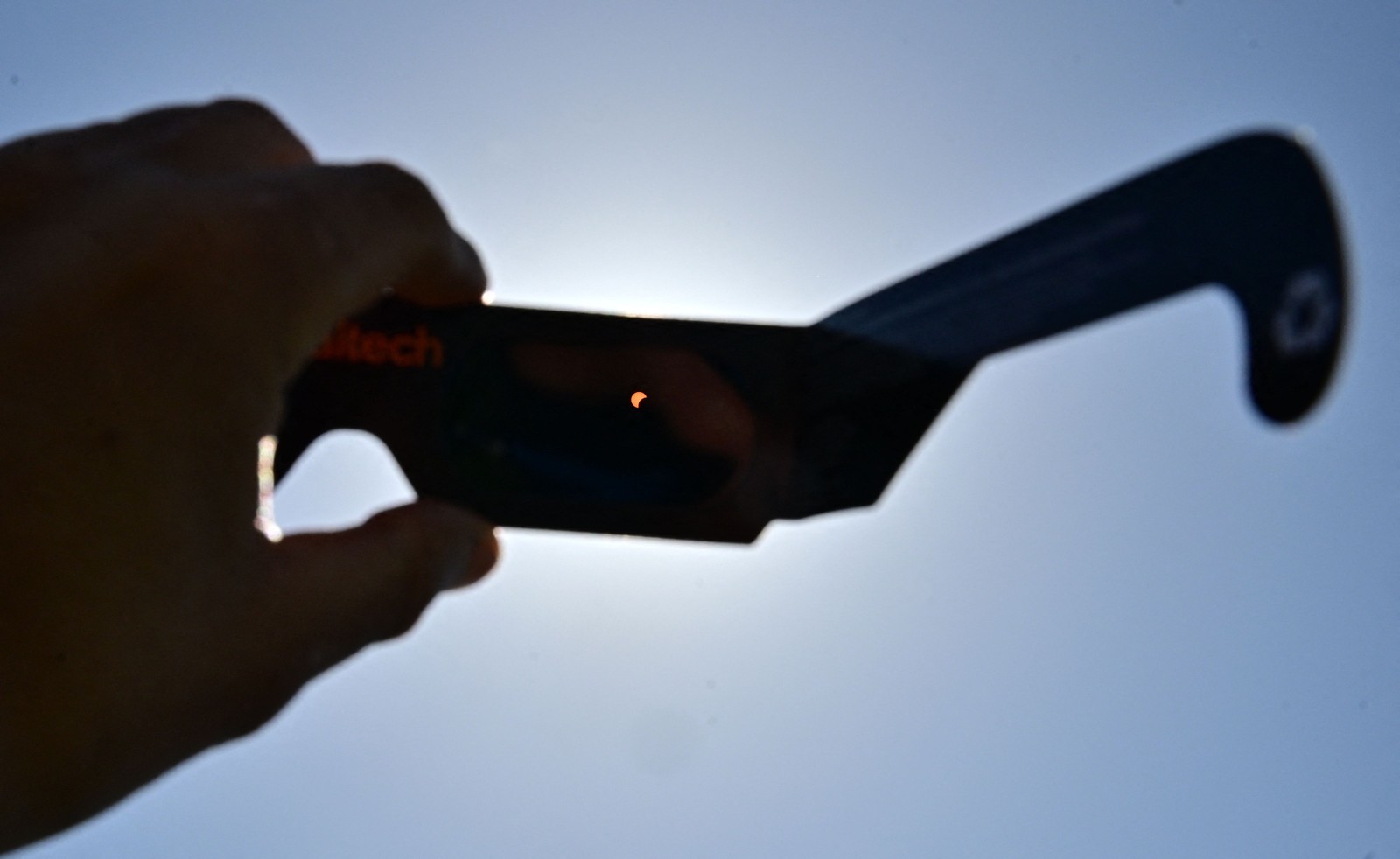 Visão do eclipse solar Através de óculos deproteção Dados àsessoasque se se reuniram para o Evesto no Caltech em Pasadena, California. -Foto: Frederic J. Brown / AFP