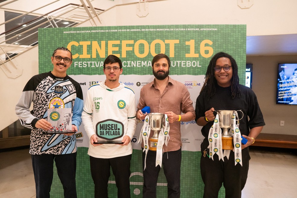 Joaquim Salles, de camisa marrom e barba, com troféu no CineFoot por "Copinha", sua estreia em longas-metragens; diretor é filho de João Moreira Salles — Foto: Divulgação / Cinefoot