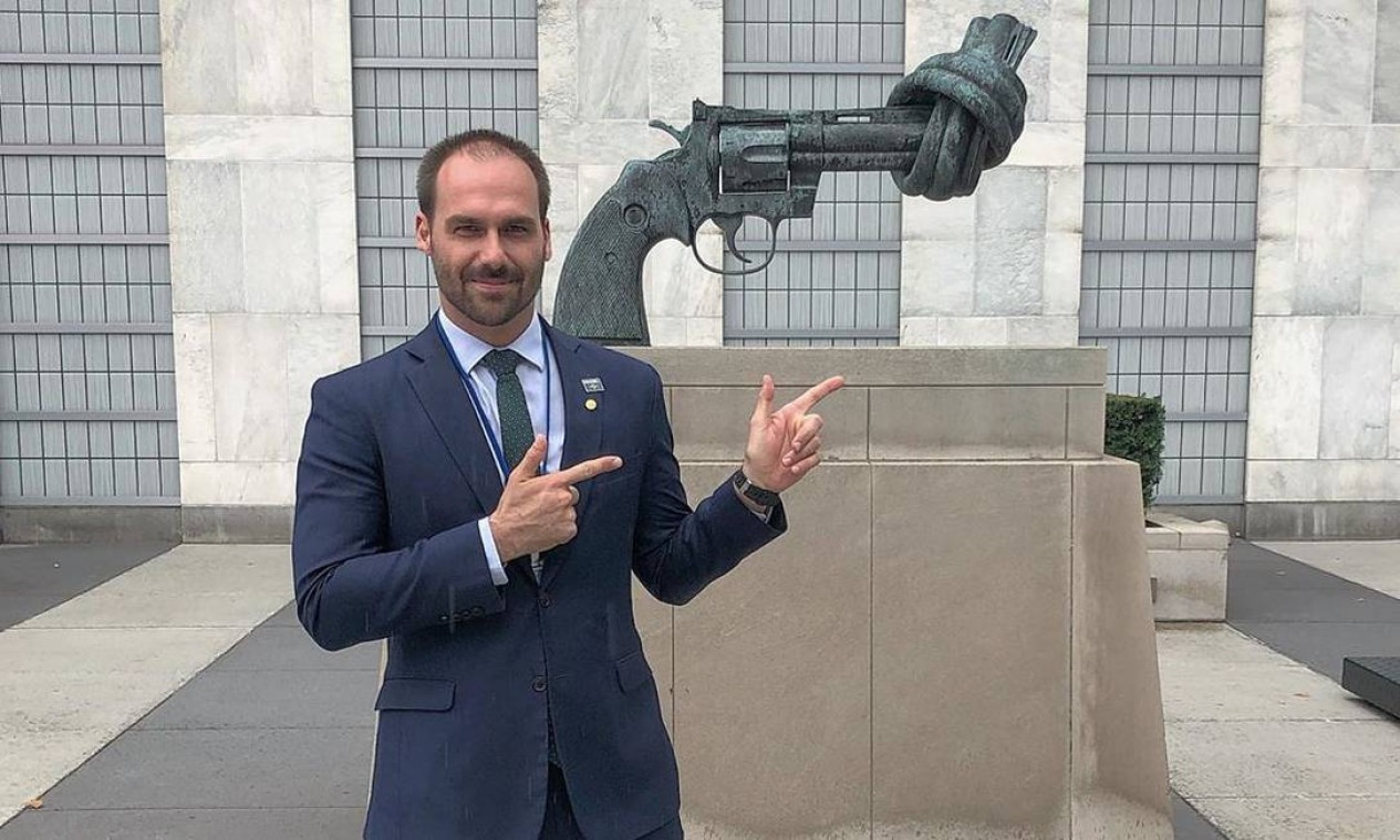 Eduardo Bolsonaro em foto postada por ele em 26 de setembro de 2019. O deputado faz sinal de armas com os dedos diante de uma escultura contra violência, em frente ao prédio da ONU, em Nova York.  — Foto: Reprodução / Instagram