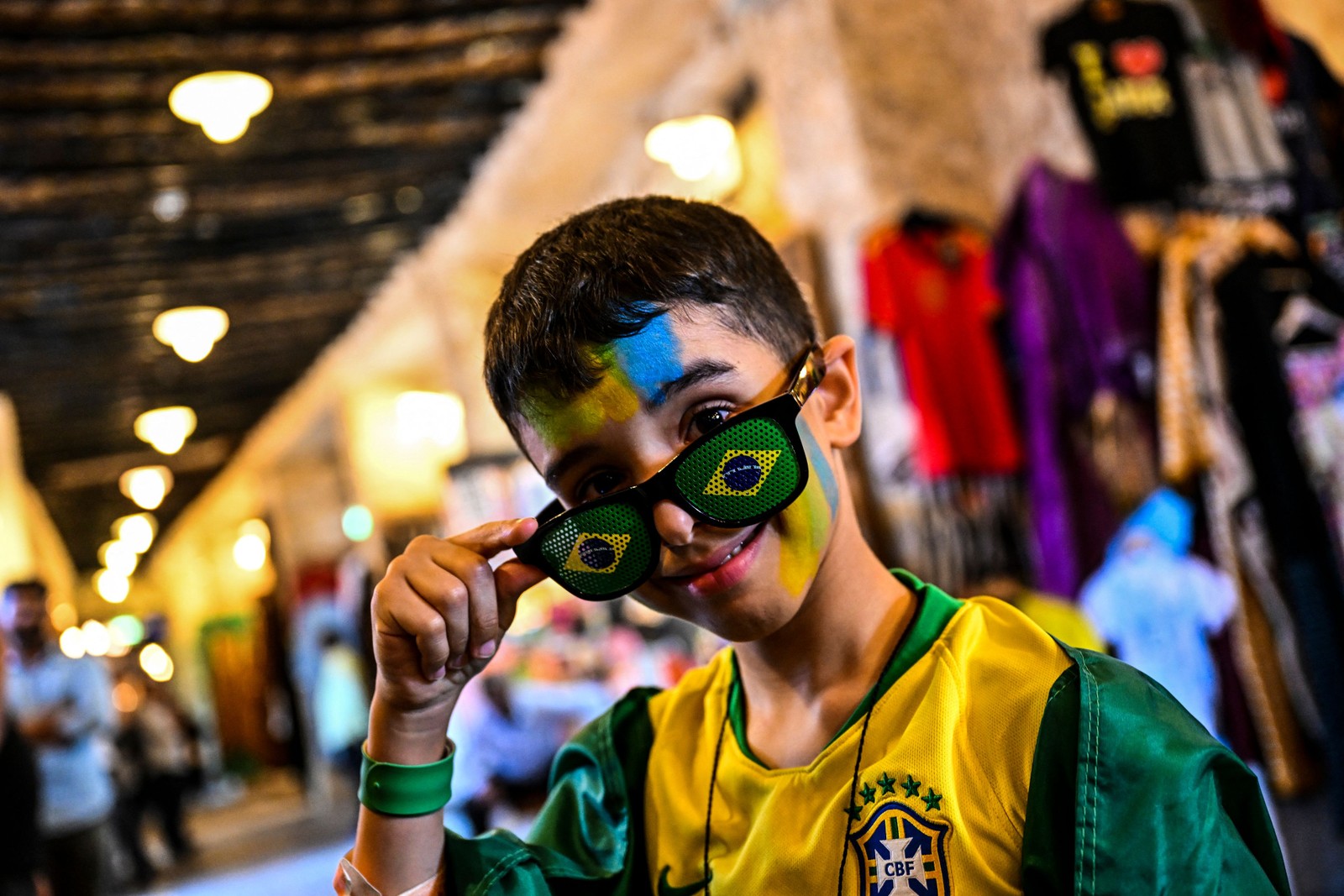 Jovem torcedor do Brasil posa no mercado Souq Waqif, em Doha, em 19 de novembro, antes do início da Copa do Mundo do Catar.  — Foto: CHANDAN KHANNA / AFP
