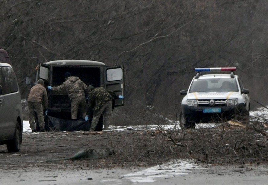 Policiais retiram corpo de civil atingido por fragmento de míssil na região metropolitana de Kiev