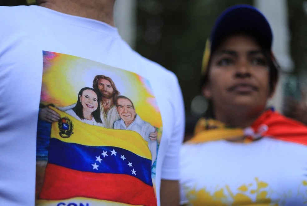 Opposition supporters at a rally in Caracas, wearing blouses with the image of María Corina and Edmundo González kissed by Jesus Christ — Photo: AFP