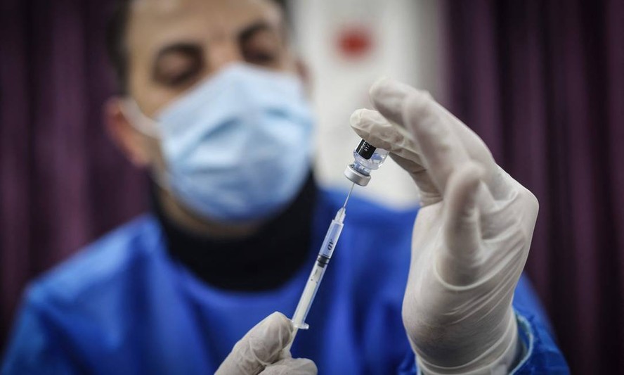 rofissional de saúde prepara uma dose da vacina da Pfizer contra a Covid-19.