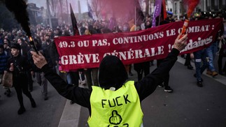 Manifestantes seguram uma faixa do Sindicato Solidaires. O governo francês promoveu uma reforma das pensões através do parlamento sem votação, usando o artigo 49.3 da Constituição — Foto:  LOIC VENANCE / AFP