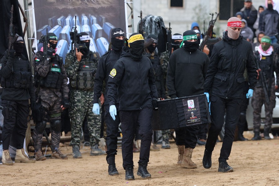 Homens fardados do grupo terrorista Hamas carregam caix&atilde;o de ref&eacute;m israelense em cerim&ocirc;nia em Gaza