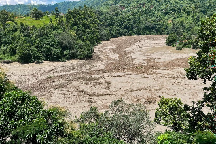 Uma torrente de água barrenta avança por um rio após inundações repentinas em Galchhi, no distrito de Dhading, no Nepal — Foto: AFP