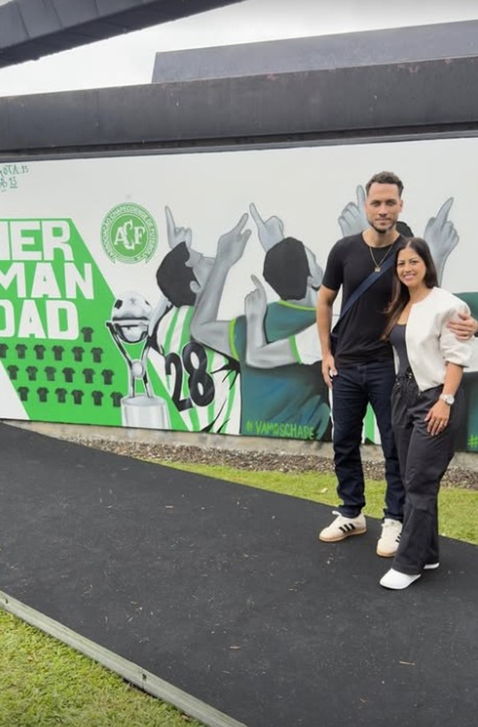 O zagueiro Hélio Neto, sobrevivente da tragédia da Chapecoense, em frente ao mural inaugurado na sede do Atlético Nacional em homenagem às vítimas — Foto: Reprodução / Instagram / @8785simoneto