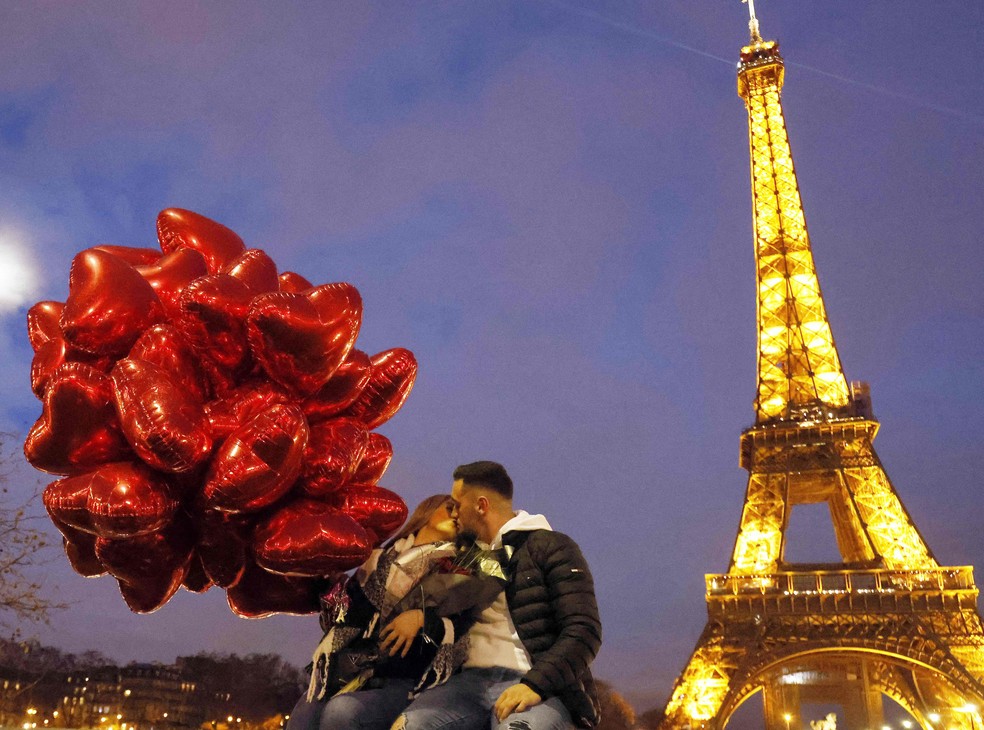 Casal se beija em frente à Torre Eiffel, em Paris  — Foto: AFP