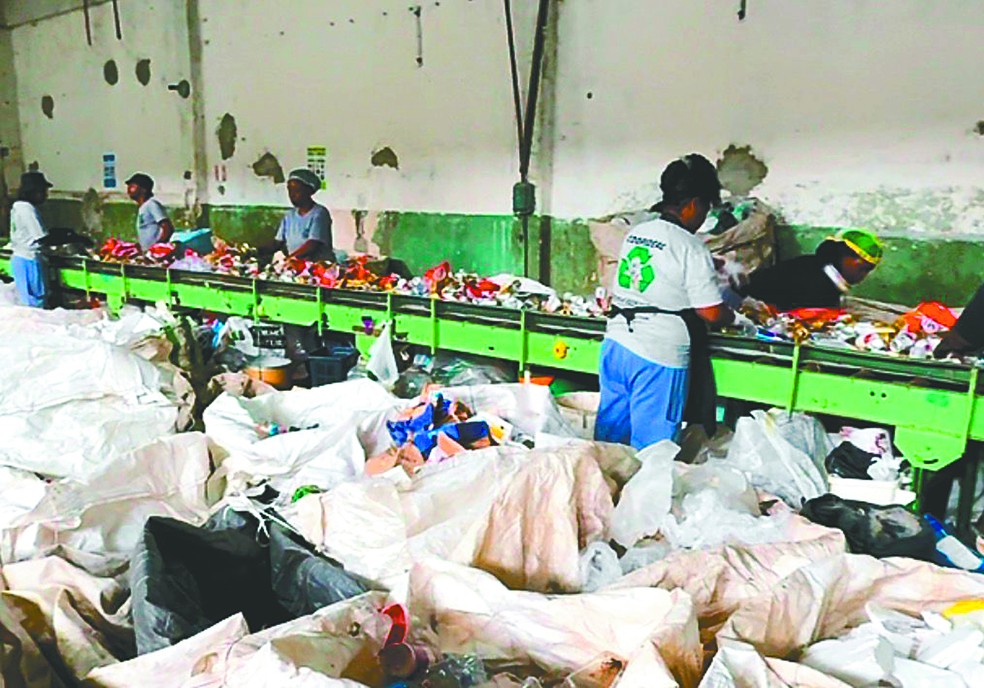 Funcionários da cooperativa Coopideal, em Maria da Graça, separam resíduos para reciclagem — Foto: Divulgação
