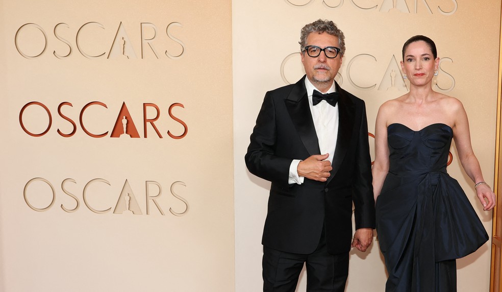 Kleber Mendonca Filho e Emilie Lesclaux no tapete vermelho do Oscar 2026 — Foto: Angela WEISS / AFP