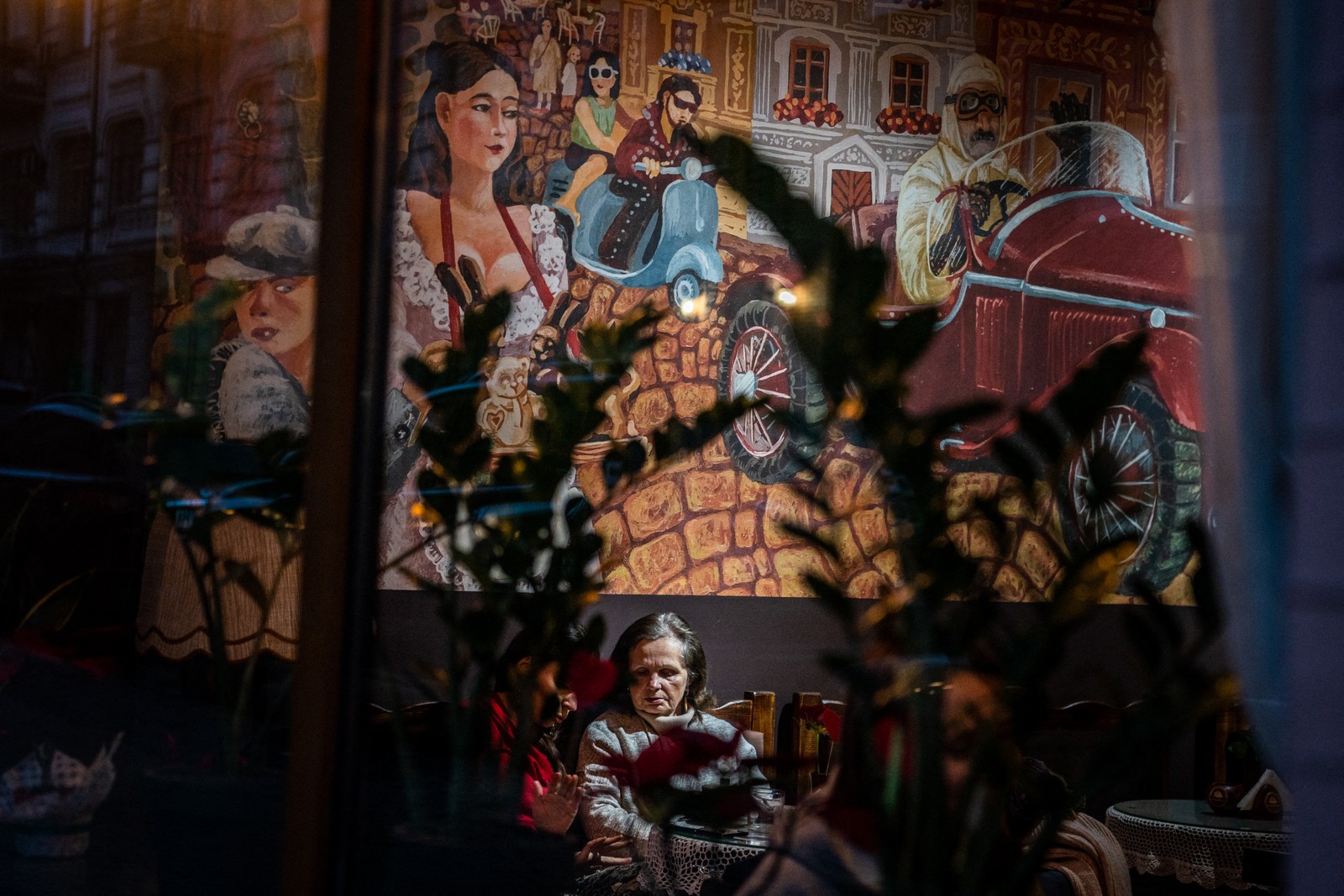 Mulheres sentam-se em uma confeitaria no bairro de Podil, em Kiev — Foto: Dimitar DILKOFF / AFP - 13/02/2023