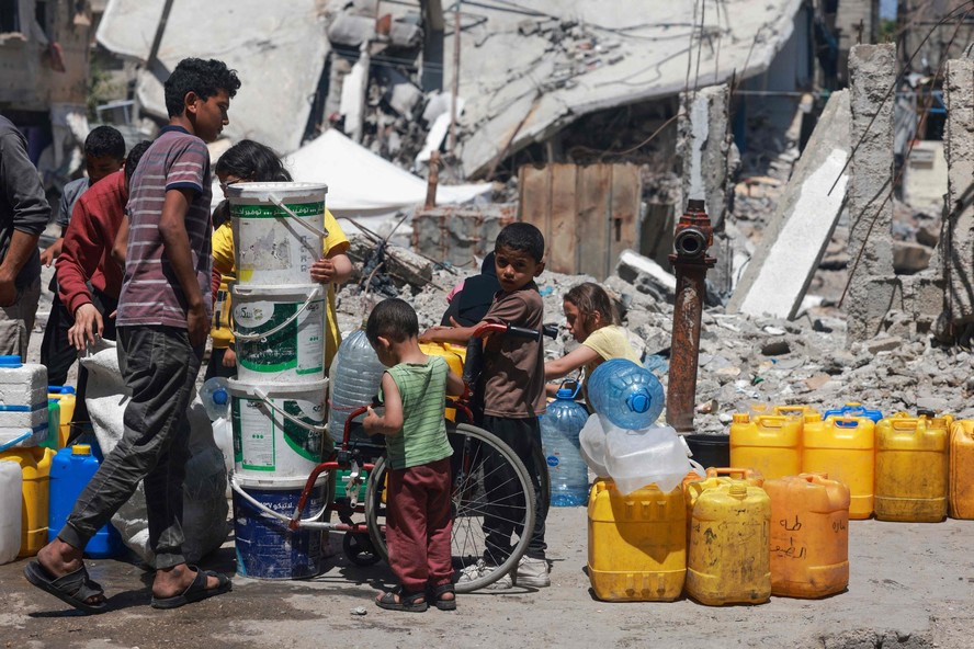 Palestinos fazem fila para encher seus contêineres com água em Rafah, na Faixa de Gaza