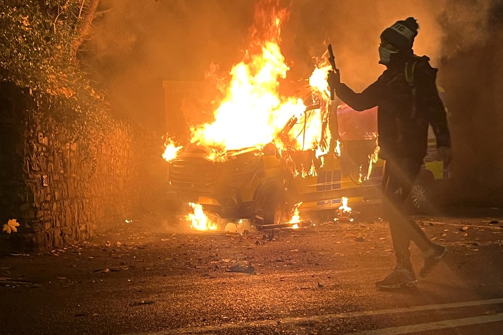 Carro é incendiado em meio a protesto anti-imigração em Dublin, na Irlanda — Foto: PETER MURPHY / AFP