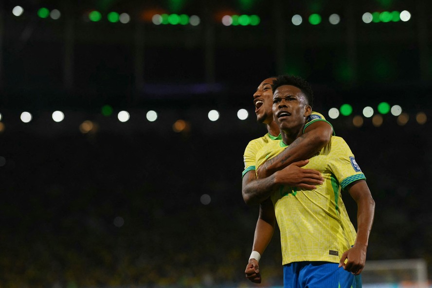 Est&ecirc;v&atilde;o &eacute; abra&ccedil;ado por Jo&atilde;o Pedro enquanto festeja seu primeiro gol pela sele&ccedil;&atilde;o brasileira