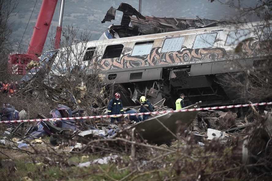 A polícia e a equipe de emergência vasculham os destroços de um vagão esmagado após um acidente de trem no vale Tempi, perto de Lárissa, Grécia, em 1º de março de 2023