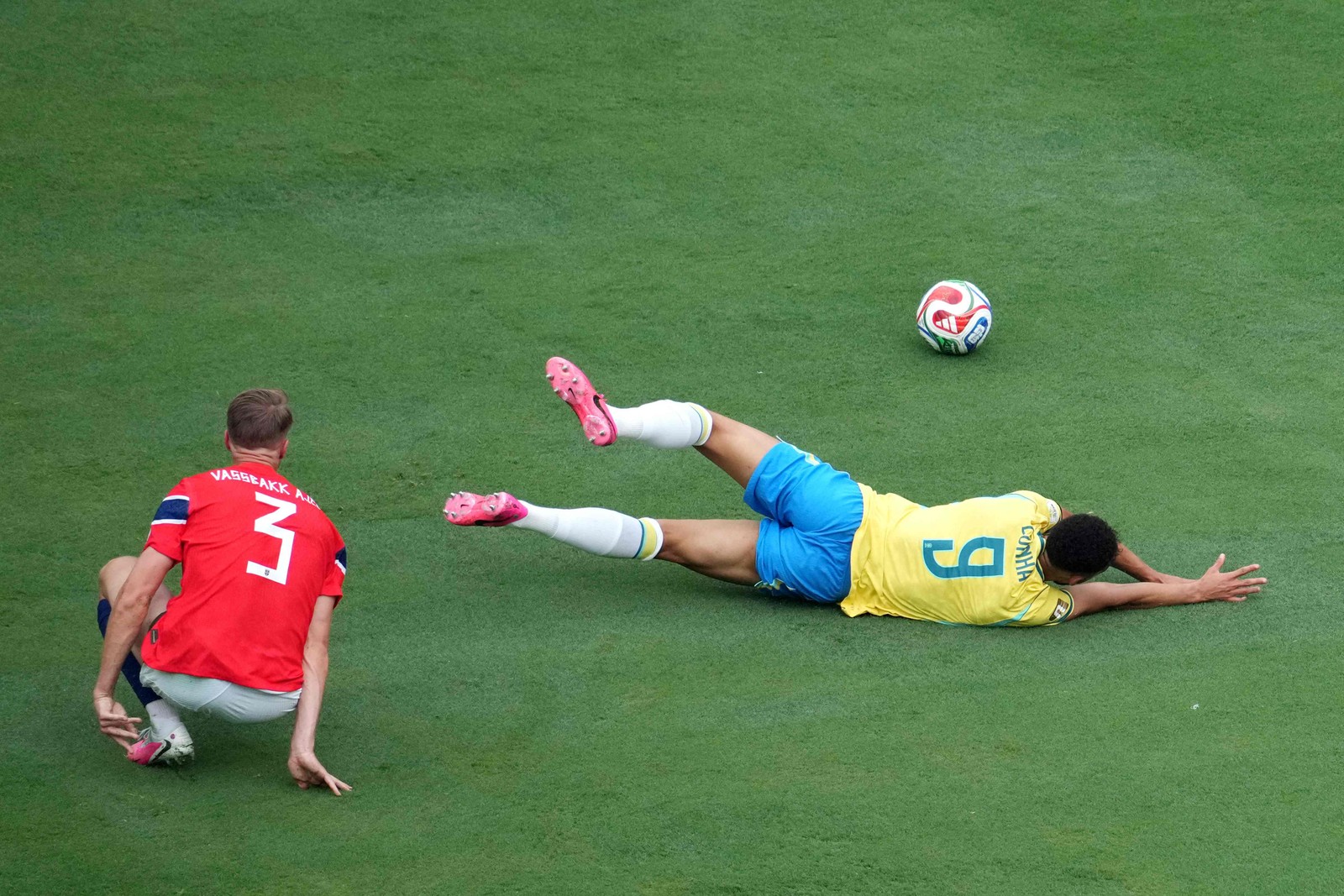 Matheus Cunha é derrubado por Kristoffer Ajer da Noruega — Foto: TIMOTHY A. CLARY / AFP)
