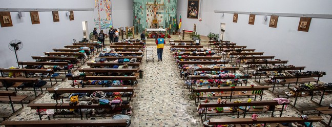 Na Pastoral do Migrante, as doações nos bancos da igreja — Foto: Edilson Dantas/Agência O Globo