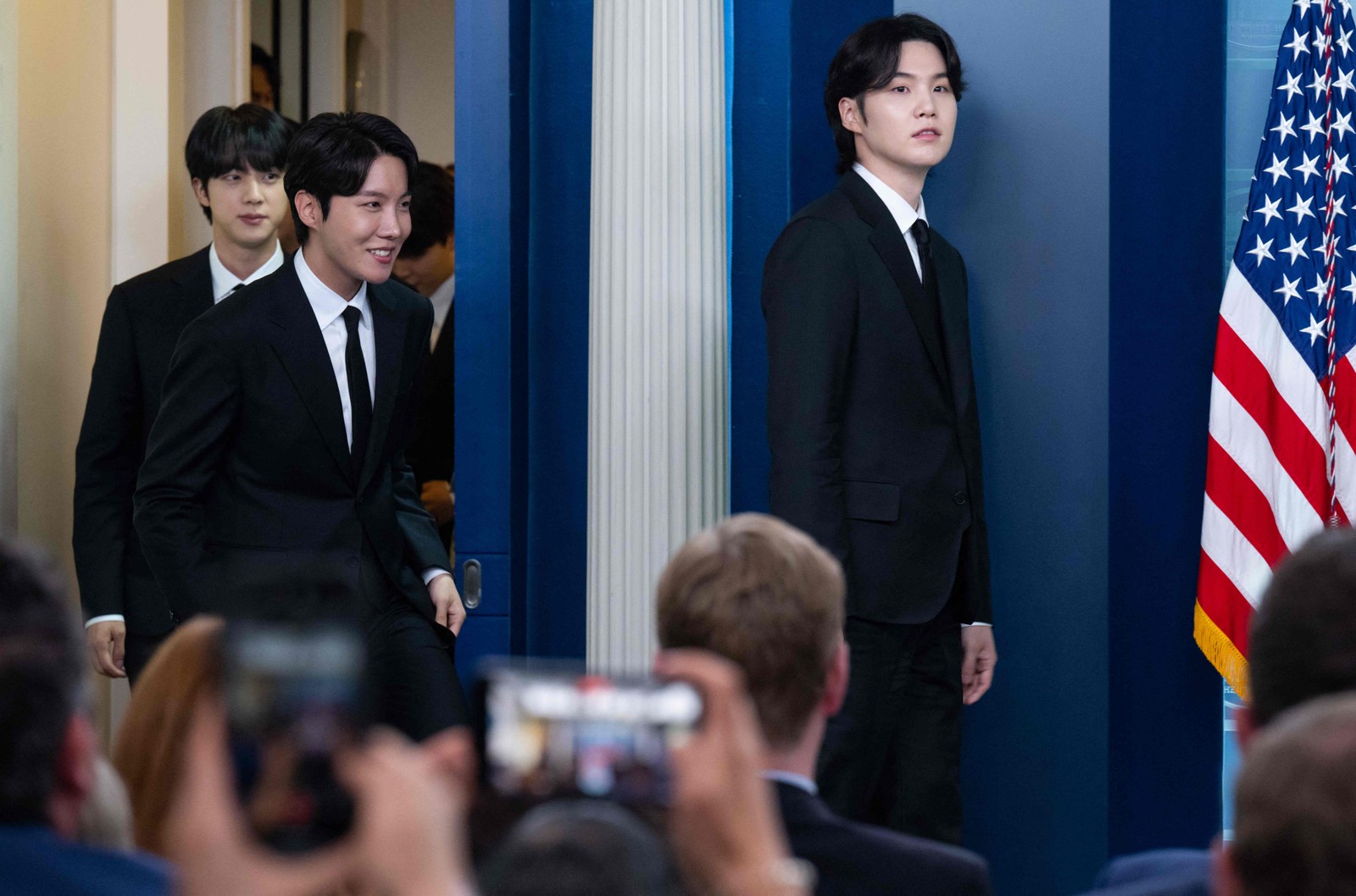 Suga, J-Hope e Jin, do BTS, entram na sala da conferência de imprensa na Casa Branca em 31 de maio de 2022 — Foto: SAUL LOEB / AFP
