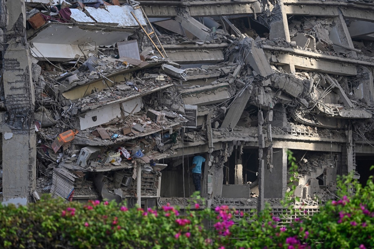 Um homem inspeciona um prédio de apartamentos que desabou após um terremoto em Catia La Mar, no estado de La Guaira, a cerca de 30 km a noroeste de Caracas, em 25 de junho de 2026 — Foto: FEDERICO PARRA / AFP