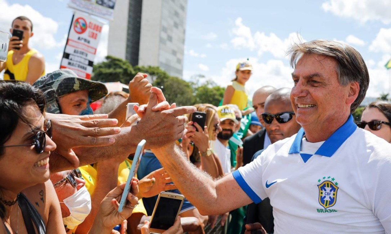 Presidente Jair Bolsonaro cumprimenta seus apoiadores durante manifestação em Brasília. Ele deveria estar em isolamento social por ter tido contato com pelo menos 10 membros de sua equipe  — Foto: SERGIO LIMA / AFP - 15/03/2020