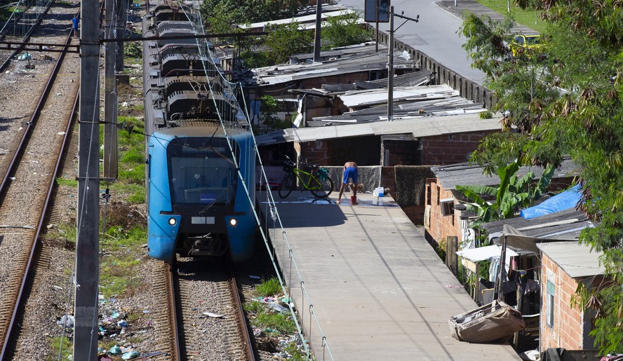 Trem passa rente a construções entre Pilares e Del Castilho, na Zona Norte do Rio