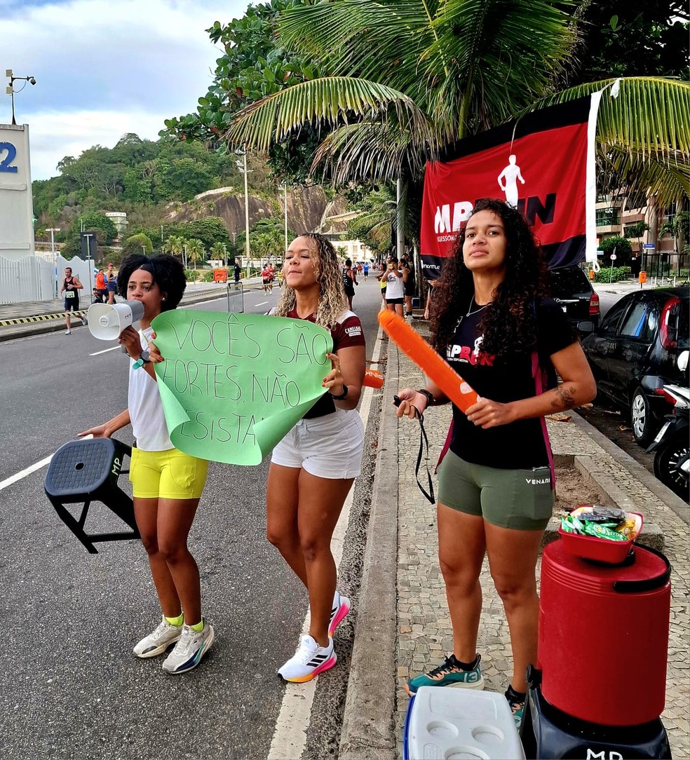 Letícia Santos, com megafone, Maiara Rangel e Ana Laura dos Santos: a assessoria MP Run, do Maracanã, tinha 30 corredores nos 42km da Maratona do Rio — Foto: Carol Knoploch/O Globo