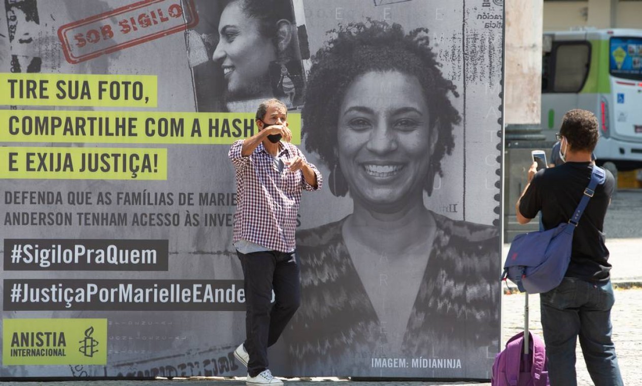 Manifestante posa em frente a cartaz para cobrar uma resposta da Justiça — Foto: Roberto Moreyra/Agência O Globo