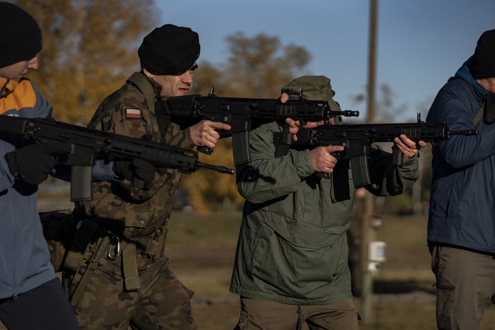 Militar polonês ensina civis a usar fuzil durante treinamento aberto à população em Varsóvia — Foto: Damian Lemanski/Bloomberg