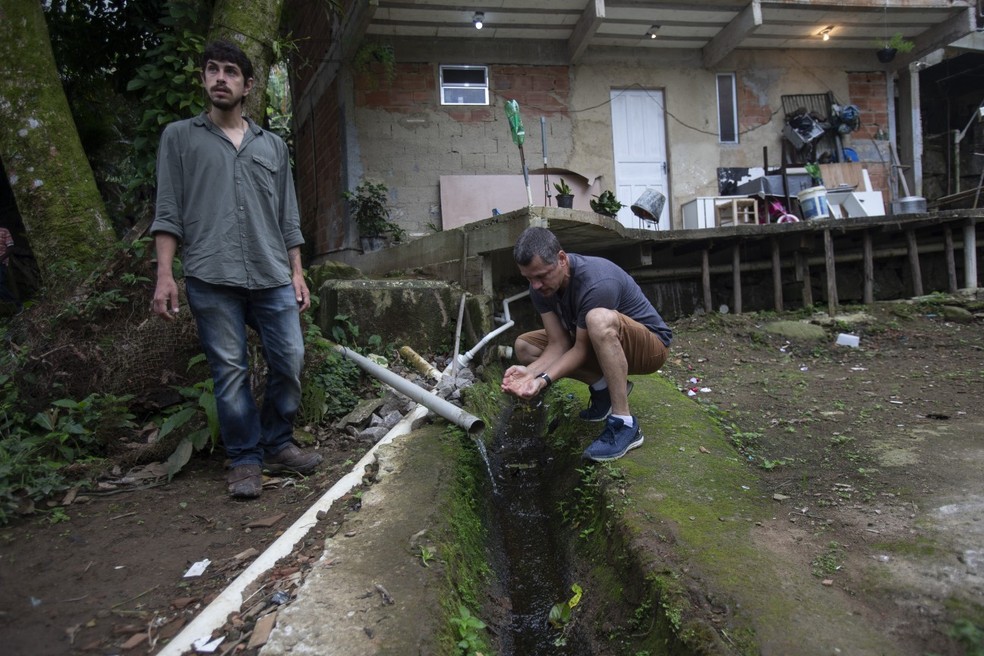 Otávio Barros mostra água que agora corre limpa dentro da comunidade — Foto: Alexandre Cassiano