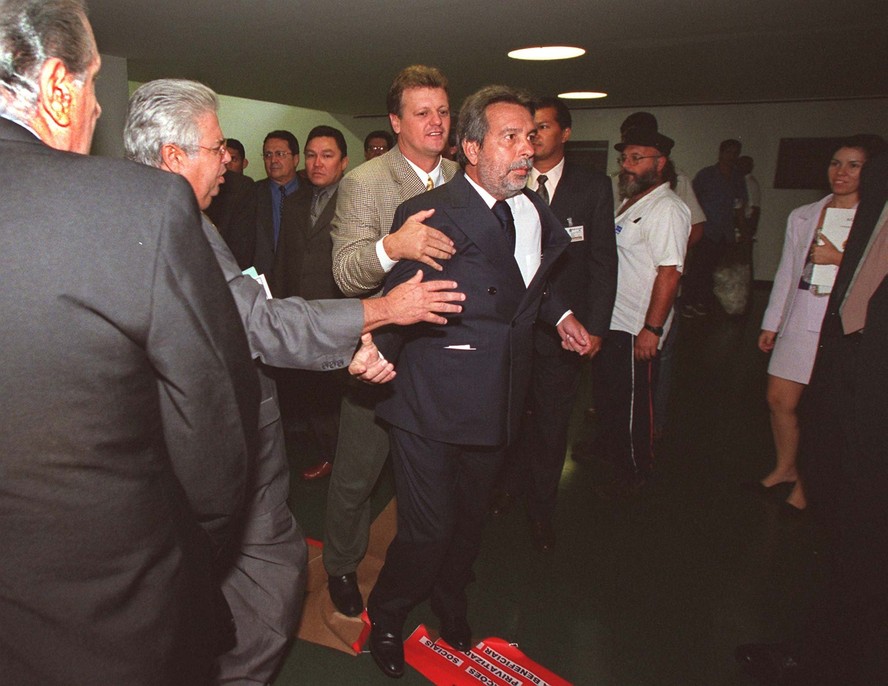 O deputado Paulo Magalhães é contido por colegas após agredir escritor na Câmara, em 2001