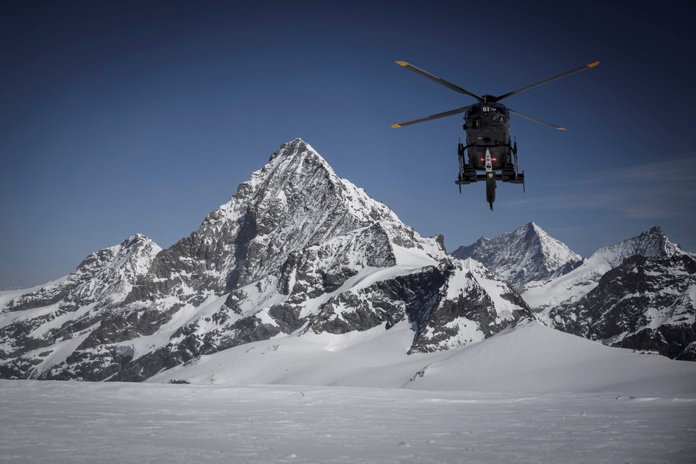 Helicóptero da Força Aérea Suíça sobrevoa a passagem de Tete Blanche entre Zermatt e Arolla, nos Alpes Suíços — Foto: GABRIEL MONNET/AFP