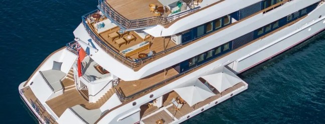 Hampshire (Feadship, 66m): Interior assinado pelo estúdio Harrison Eidsgaard, com atmosfera inspirada na Nova Inglaterra. Oferece beach club, spa, academia completa e suíte do proprietário com varanda retrátil e acesso secreto à ponte de comando.