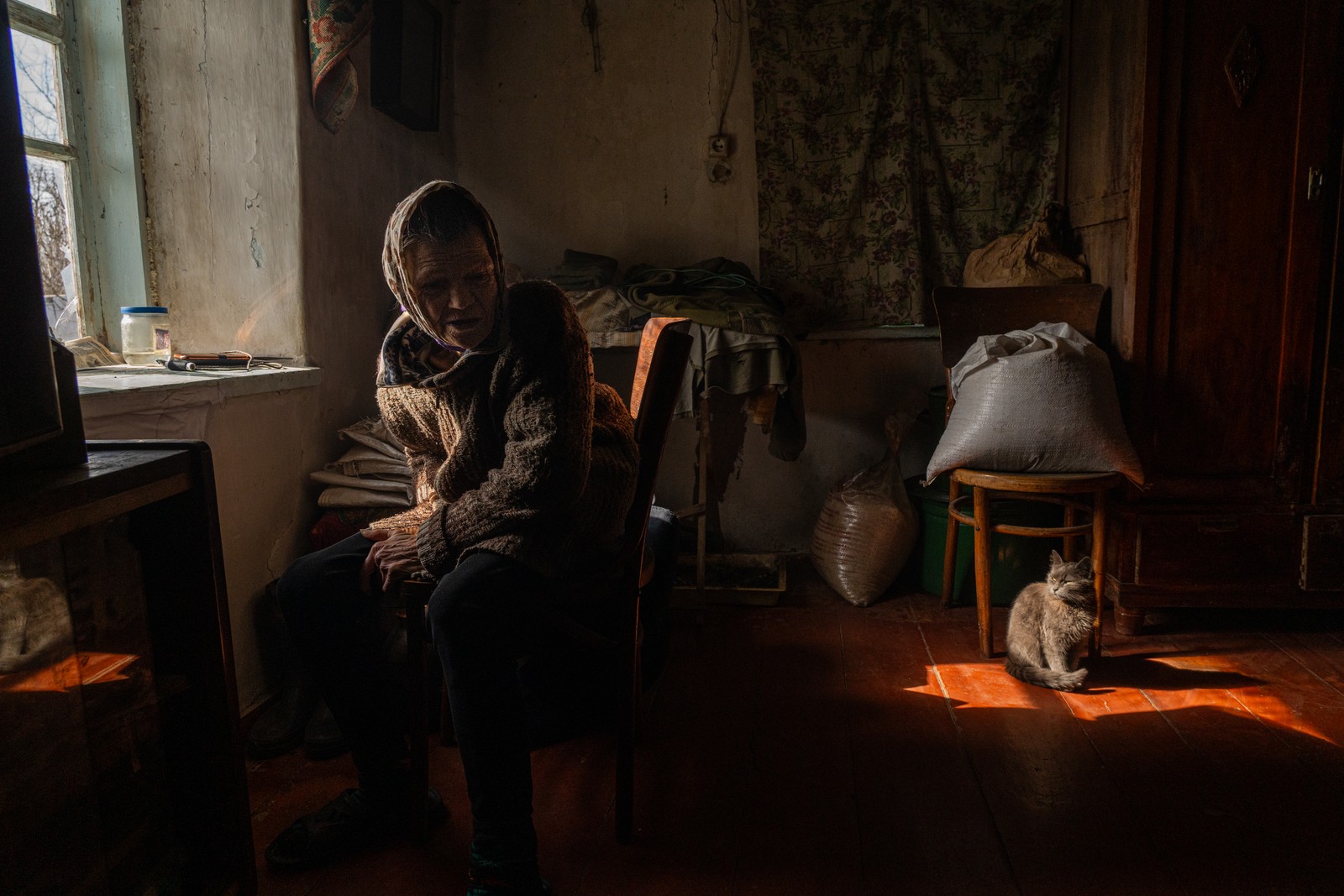 Paraskovya e a sua família decidiram ficar em sua casa mesmo com a guerra chegando cada vez mais perto de sua cidade semi-destruída. A senhora diz estar com medo das explosões constantes, mas conta ter ainda mais medo de se tornar uma refugiada. Foto tirada em Ocheretyno, Oblast de Donetsk, Ucrânia — Foto: Yan Boechat