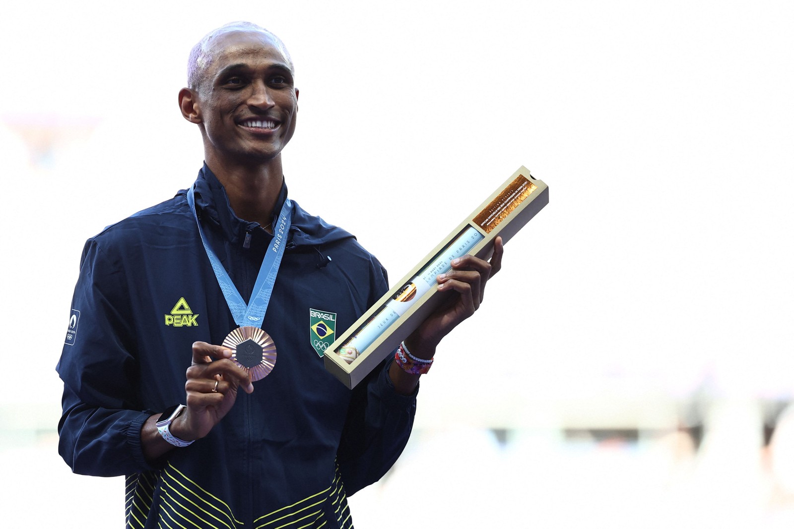 Alison dos Santos, o Piu, com a medalha de bronze no pódio pelo desempenho na prova dos 400m com barreiras no atletismo das Olimpíadas de Paris 2024 — Foto: Anne-Christine POUJOULAT / AFP