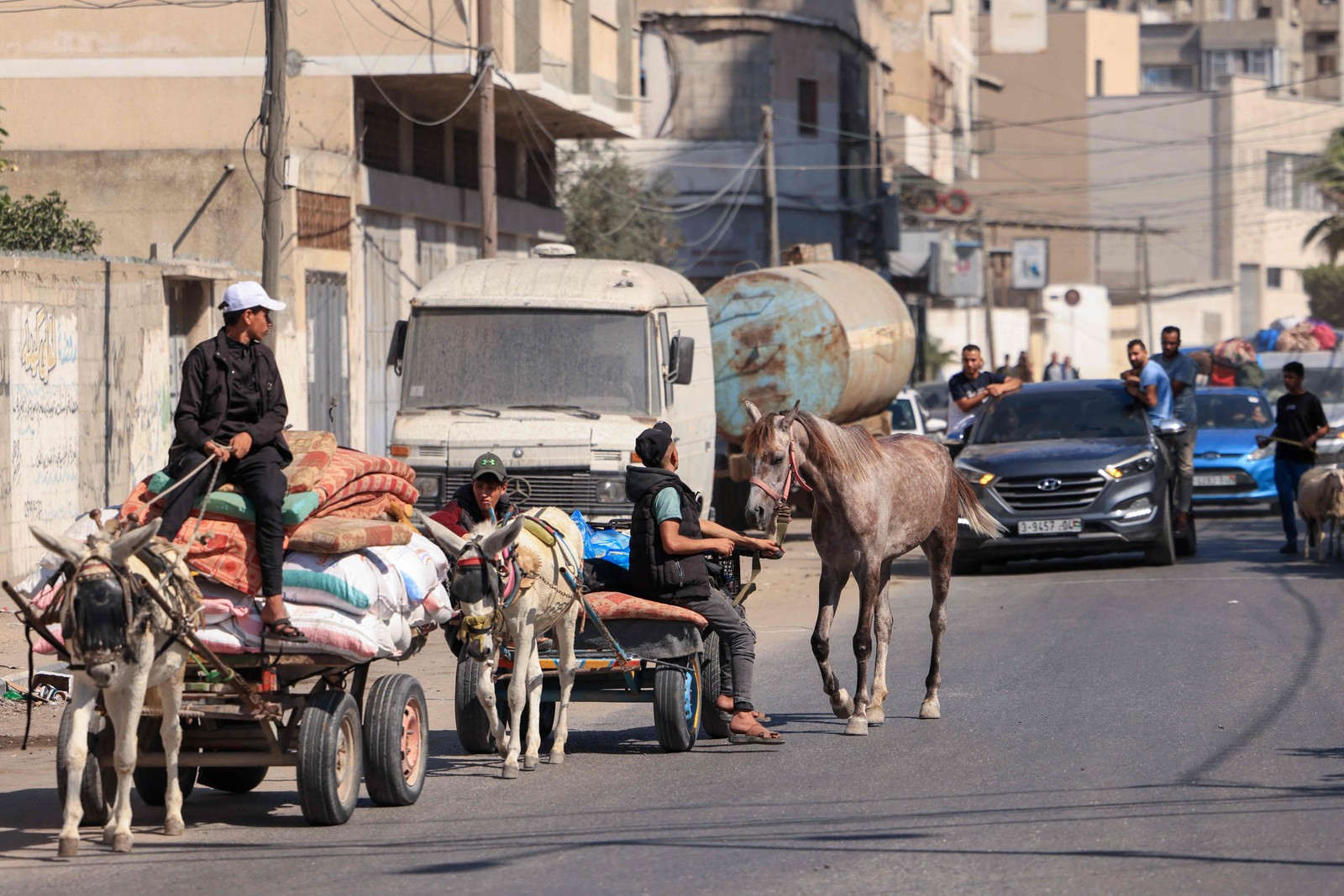 Palestinos com seus pertences fogem para &aacute;reas mais seguras na Cidade de Gaza ap&oacute;s ataques a&eacute;reos israelenses &mdash; Foto: Mahmud Hams / AFP