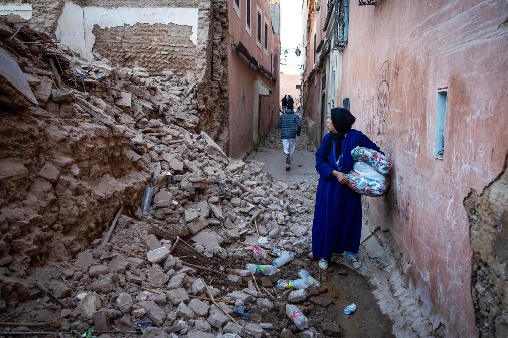 Uma mulher olha para os escombros de um edifício na cidade velha de Marrakech, no Marrocos — Foto: Foto de Fadel Senna/AFP