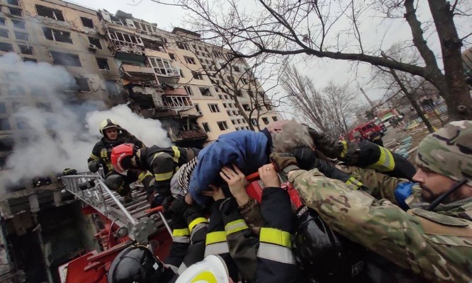 Mulher é retirada de edifício atingido por projétil russo em Obolon, distrito de Kiev