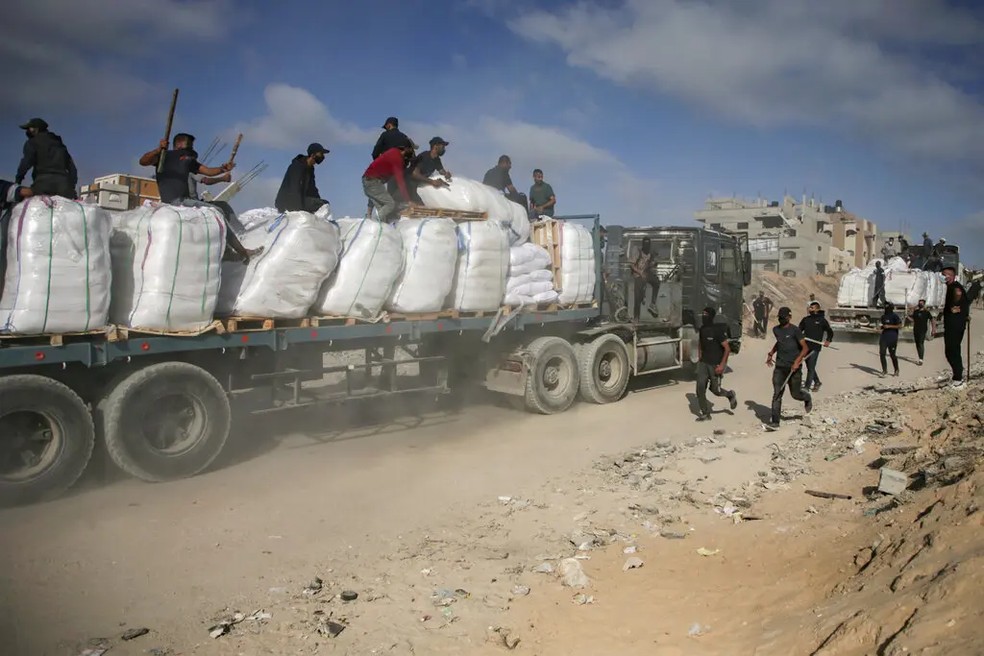 Palestinos em caminhões de ajuda humanitária rumo à Cidade de Gaza — Foto: Saher Alghorra / The New York Times