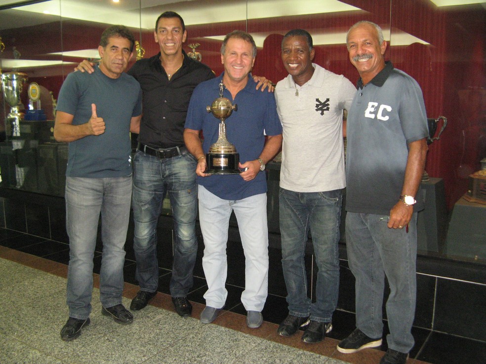 Zico e Adílio posando com o troféu da Libertadores de 1981, junto com outros campeões — Foto: Rafael Cotta/Divulgação