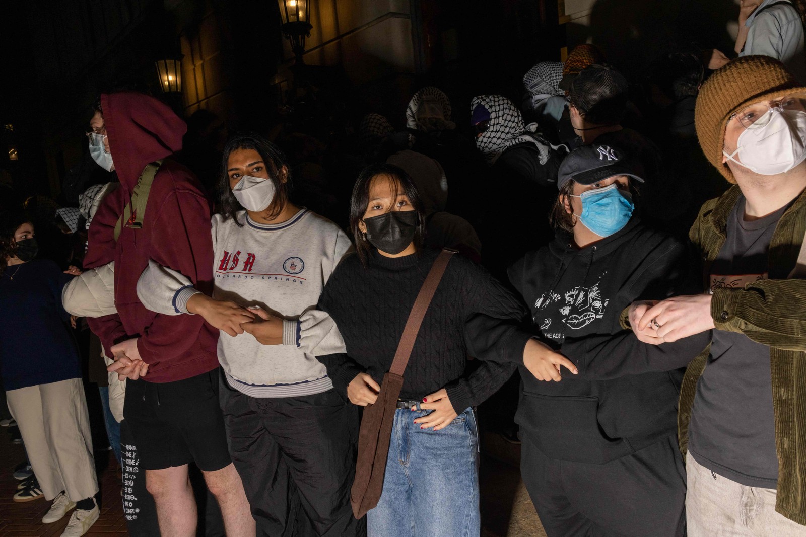 Estudantes/manifestantes cruzam os braços para proteger autoridades em potencial contra o alcance de colegas manifestantes que se barricaram dentro do Hamilton Hall, — Foto: Alex Kent/Getty Images/AFP