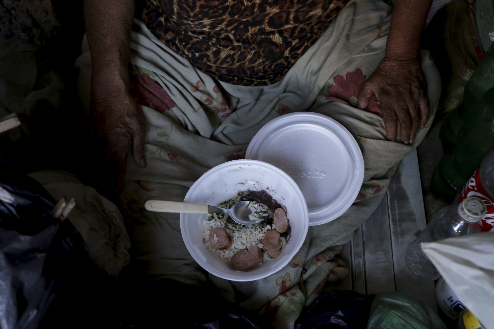 Dona Juraci da Silva, 73 anos, come uma quentinha doada pela igreja. A idosa mora em um barraco às margens da linha verde, em Acari.  — Foto: Domingos Peixoto / Agência O Globo