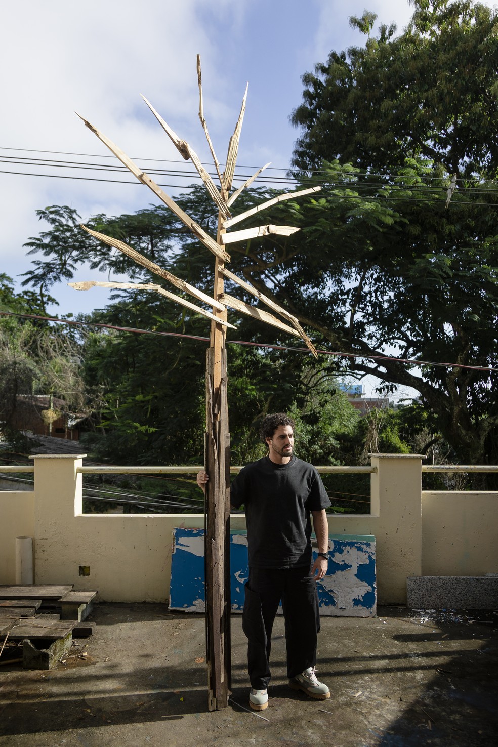 Douglas Knesse e escultura que lembra coqueiro — Foto: Leo Martins