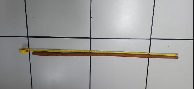 O bastão de madeira, com 1,60 m de comprimento (um metro e sessenta centímetros), encontrado no apartamento — Foto: Reprodução