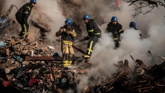 Bombeiros ucranianos trabalham em um prédio destruído após um ataque de drones em Kiev. — Foto: Yasuyoshi CHIBA / AFP