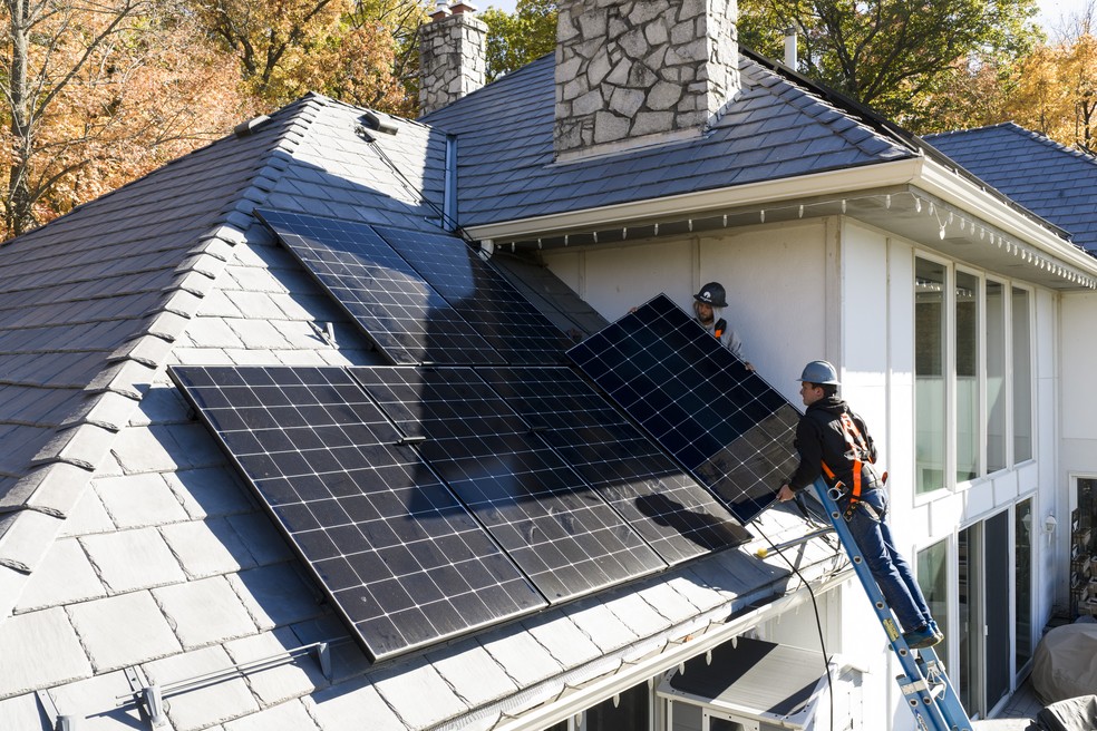 Instaladores da empresa de energia solar Wolf River Electric trabalham em uma residência em North Oaks, Minnesota — Foto: Tim Gruber/The New York Times
