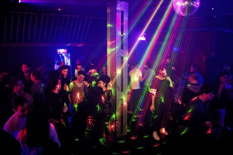 Homem dançando com amigos e festejando na discoteca em boate. jovem clubber  afro-americano se divertindo e fazendo movimentos na pista de dança em  concerto de música eletrônica no clube