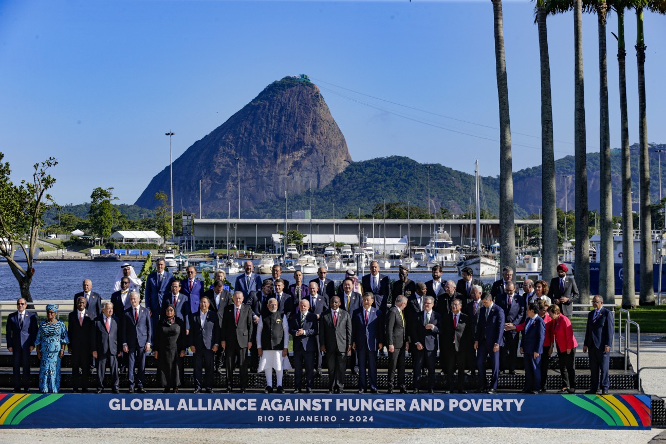 As árvores, a placa e o poste no caminho da foto do G20