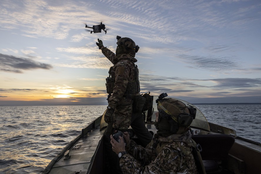 Voluntários das Forças Especiais ucranianas soltam drone no Rio Dnieper.