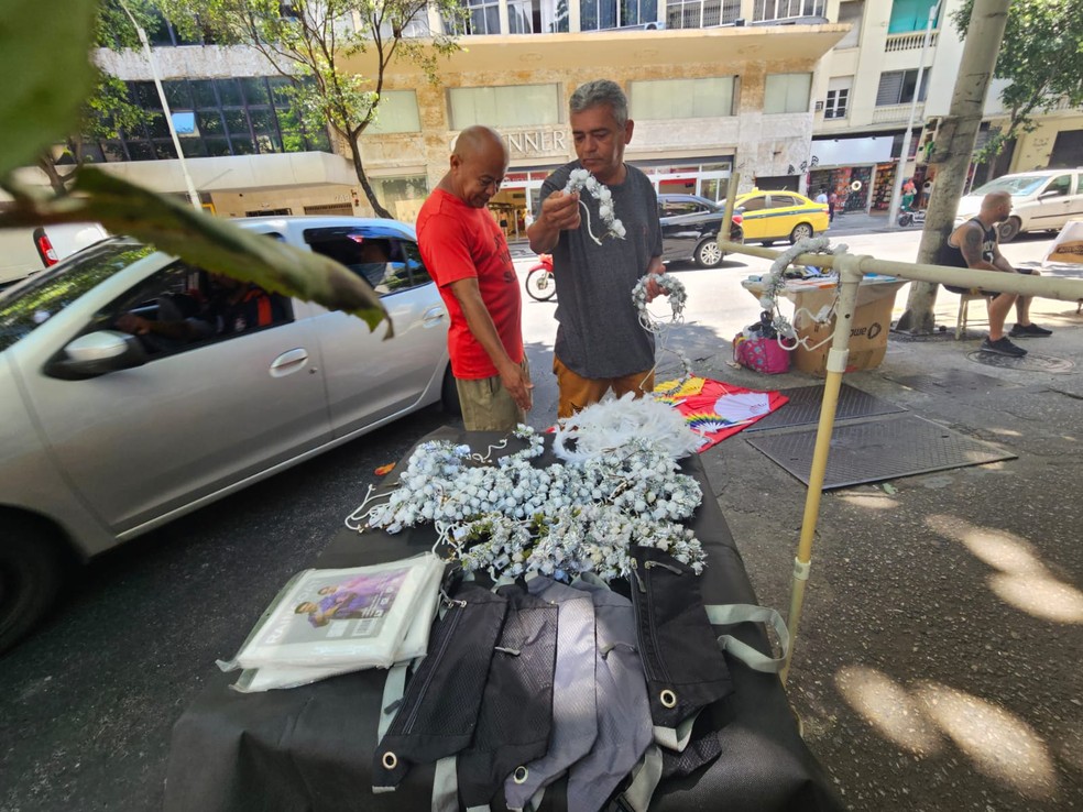 Vendedor ambulante vendendo coroas de flores e porta-dólares em Copacabana - Foto: Laila Youssef/Agência O Globo
