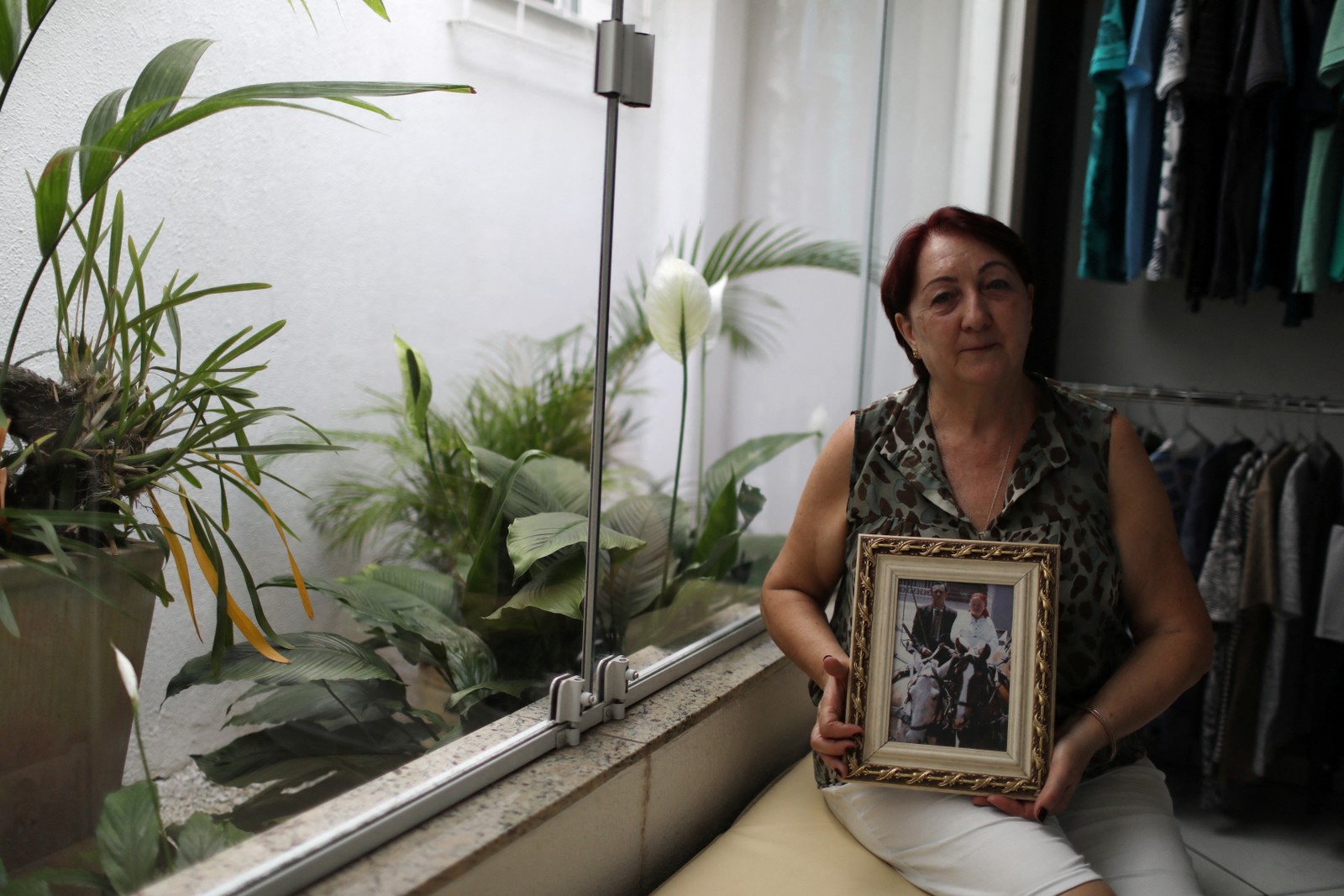 Nadia Rurak Techy, 66 anos, empresária de ascendência ucraniana, segura uma foto de seus pais, em sua loja em Prudentópolis, Reuters